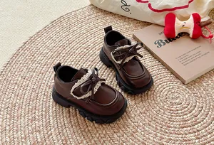 Elegante braune Mädchenschuhe im britischen Stil mit Spitzenbesatz und Schleifendetail.