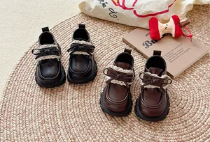 Detailansicht eleganter britischer Lederschuhe für Mädchen mit zarter Spitze und Schleife