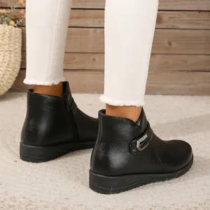 Primer plano de cómodos botines de invierno negros con hebilla decorativa de diamantes