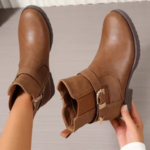 Détail de bottines Chelsea rétro marron style Western avec boucle dorée et petit talon bloc tendance