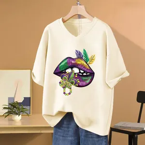 Close-up of Mardi Gras glitter lips and fleur-de-lis print on a cream V-neck T-shirt