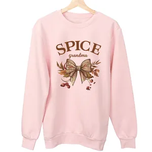 Detalle de sudadera rosa con lazo Spice Grandma y estampado gráfico de bayas de otoño.