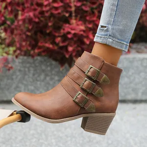 Vue détaillée des bottines Chelsea marron avec trois boucles métalliques décoratives