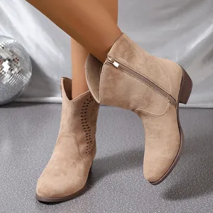 Détail de bottines Chelsea style western en daim beige avec fermeture éclair.