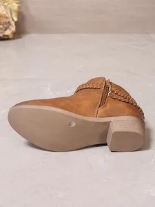 Vue détaillée de bottines Chelsea de style western marron avec bride tressée et talon.