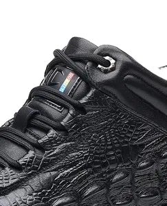 Close-up of black men's winter boot with crocodile embossed leather texture