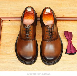 Top view of premium brown leather round-toe Oxford shoes with elegant brogue details