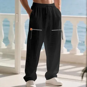 Detail of men's loose black linen pants with functional zippers and drawstring waist.