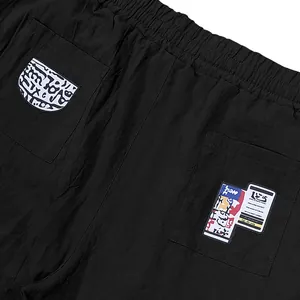 Close-up of black casual linen trousers featuring decorative back pocket patches.