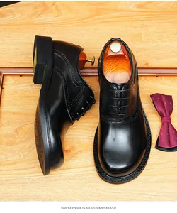 Detailed view of black leather Oxford shoes with Brogue wingtip on a wooden surface