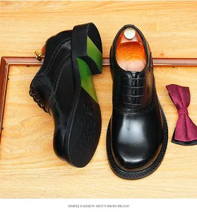 Top view of handmade black leather Oxford shoes with brogue details and green sole.