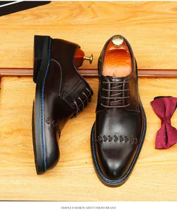 Gros plan de chaussures habillées en cuir marron foncé pour homme sur fond bois