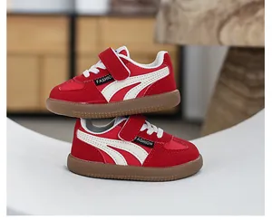 Side view of red children's sneakers featuring white stripes and brown gum soles