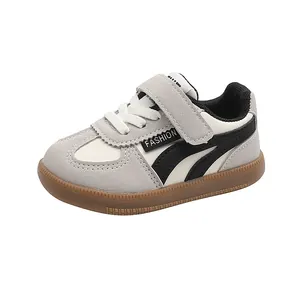 Detailed side view of grey and white toddler anti-slip sneakers with classic gum sole