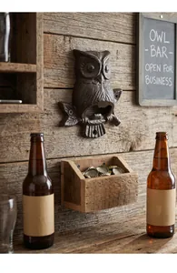 Ouvre-bouteille hibou vintage en fonte monté sur un mur en bois avec récupérateur