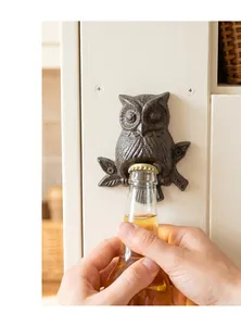 Vue détaillée d'un décapsuleur hibou vintage en fonte fixé au mur ouvrant une bière
