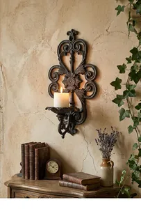 Elegant vintage cast iron wall sconce candle holder displayed in a rustic room setting