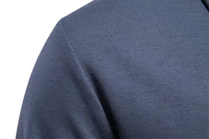 Detailed view of the breathable pique fabric texture on a classic blue men's polo shirt.