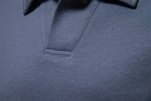 Macro view showing the breathable pique fabric and collar stitching of a blue Polo shirt