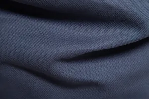 Macro detail of the breathable blue-grey pique knit fabric for a men's polo shirt