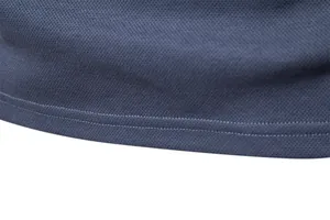 Detailed macro shot showing double-stitched hem of a navy blue piqué fabric men polo shirt