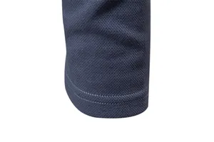 Macro detail of navy blue pique cotton polo shirt sleeve showing double-stitched hem
