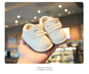 Detailed view of cream quilted leather baby shoes featuring elegant lace and heart embroidery detail