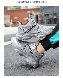 Vue lifestyle en extérieur de chaussures de course en mesh gris respirant pour garçons