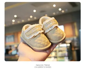 Close-up of beige quilted baby walking shoes with lace trim and soft sole