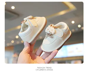 Cream-colored toddler walking shoes featuring a cute rabbit motif and soft Velcro straps