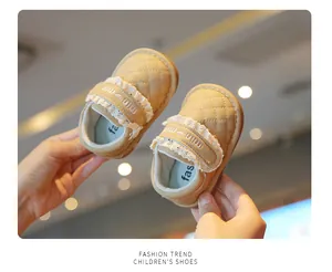 Close-up view of beige quilted toddler walking shoes with lace trim and flexible soft sole