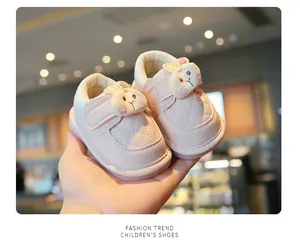Detailed view of pink baby walking shoes featuring a cute plush cartoon bunny decoration