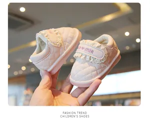 Detailed view of pink quilted baby girl shoes with delicate lace and velcro strap.