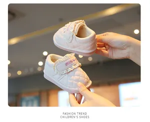 Detailed view of pink quilted baby walker shoes with lace trim and velcro strap