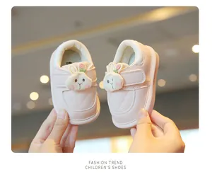 Close-up of pink cartoon bunny baby walking shoes being held up for detail display
