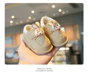 Close-up of beige baby walking shoes featuring a cute cartoon bunny and quilted texture