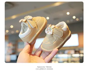 Close-up view of beige baby walking shoes featuring a cute cartoon rabbit decoration
