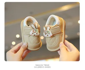 Detailed view of beige baby walking shoes with cute cartoon rabbit and velcro strap
