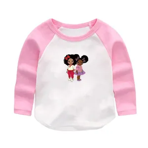 Détail d'un t-shirt raglan pour bébé avec manches roses et imprimé graphique filles