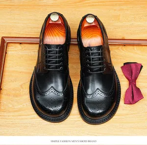 Bovenaanzicht van luxe zwarte leren Brogue schoenen met schoenspanners en rode strik.