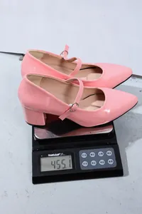 Detailed view of elegant pink Mary Jane dance shoes showing a weight of 455.1g on a scale