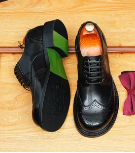 Detailweergave van zwarte lederen herenbrogues met decoratieve perforaties