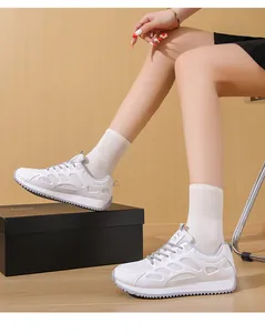 Vista laterale di sneakers bianche in mesh con zeppa da donna indossate con calzini