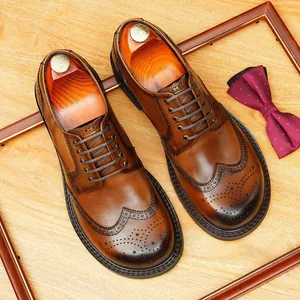 Klassieke bruine leren herenschoenen met brogue-details en vetersluiting