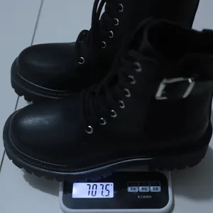 Close-up showing the weight of the black platform combat boots on a digital scale.