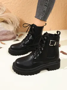 Detailed side view of black British style platform boots with buckle and laces