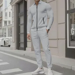 Full body shot of a men's light grey textured zipper tracksuit two-piece set outdoors