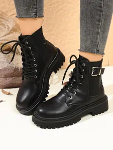Detailed view of stylish black platform ankle boots featuring lace-up front and side buckles
