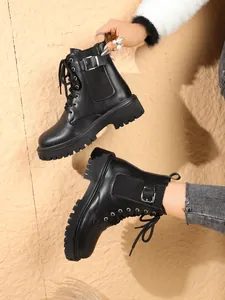 Close-up of black British style thick-soled boots with buckle and lace-up details