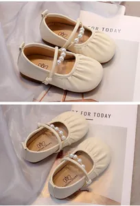 Primer plano de zapatos Mary Jane crema para niñas con elegantes correas de perlas y cuero